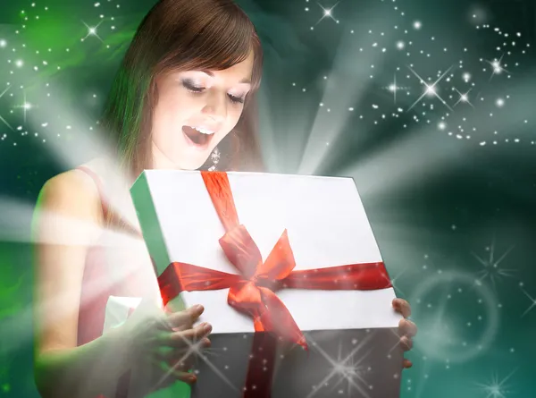Красивая девушка открывает X-Mass подарок магии. Рождество Лицензионные Стоковые Изображения