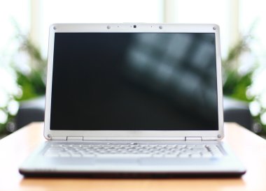 Thin laptop on office desk clipart