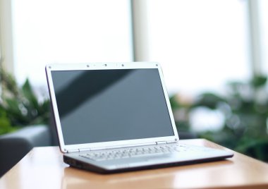 Thin laptop on office desk clipart