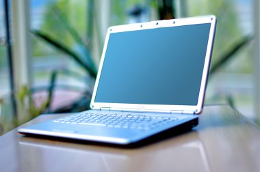 Thin laptop on office desk clipart