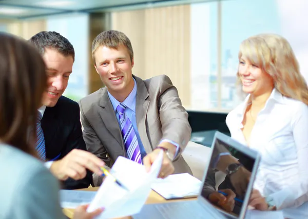 Uma equipe de negócios de sucesso com um documento em uma mesa com um laptop — Fotografia de Stock