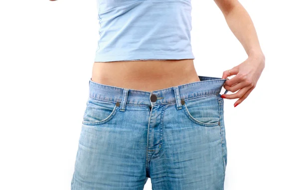 Felice giovane donna in vecchi jeans pantalone dopo aver perso peso — Foto Stock