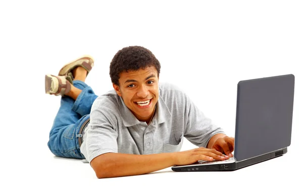 Счастливый молодой человек, работающий на ноутбуке, изолированный на белом фоне — стоковое фото