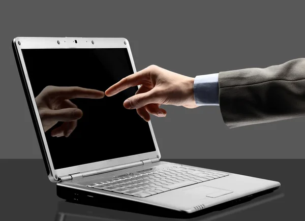 Close-up da mão masculina com indicador apontando para a tela do laptop sobre preto — Fotografia de Stock