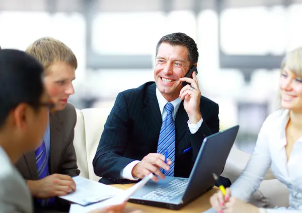 Homem de negócios falando ao telefone em uma reunião — Fotografia de Stock