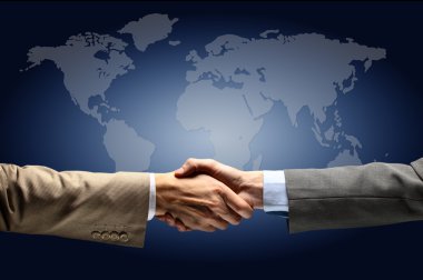 Handshake with map of the world in background clipart