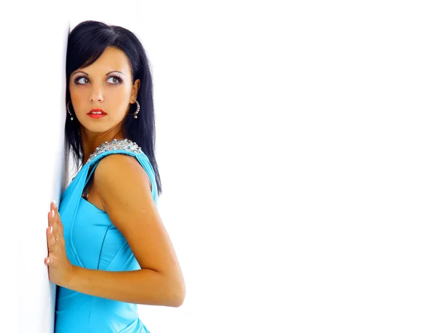 Kvinna i en blå klänning som poserar på en vit bakgrund — Stockfoto