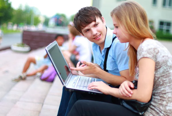 Nahaufnahme glücklicher junger Freunde mit Laptop — Stockfoto