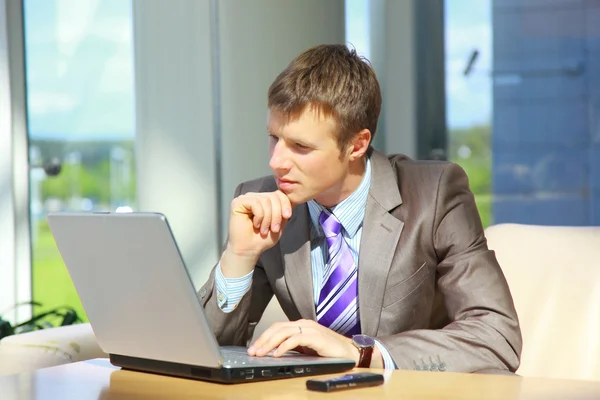 Businessman working on laptop computer at office lobby — Stock Photo, Image