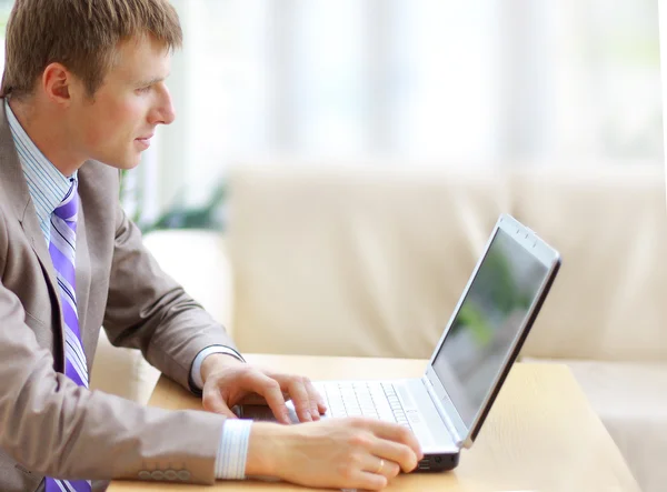 Επιχειρηματίας που κάθεται στο γραφείο σε γραφείο, εργάζεται με φορητό υπολογιστή, lookin — Φωτογραφία Αρχείου