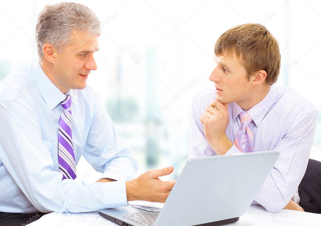 Two businessmen looking at a laptop in office