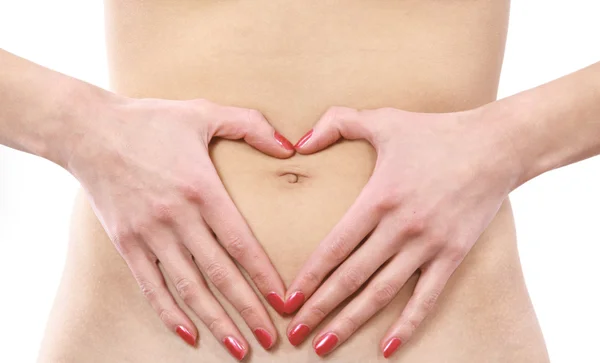 一个女人的手在肚子上形成心符号 — 图库照片
