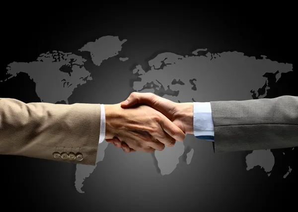 Handshake with map of the world in background — Stock Photo, Image