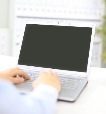 Person Typing on a modern laptop in an office clipart