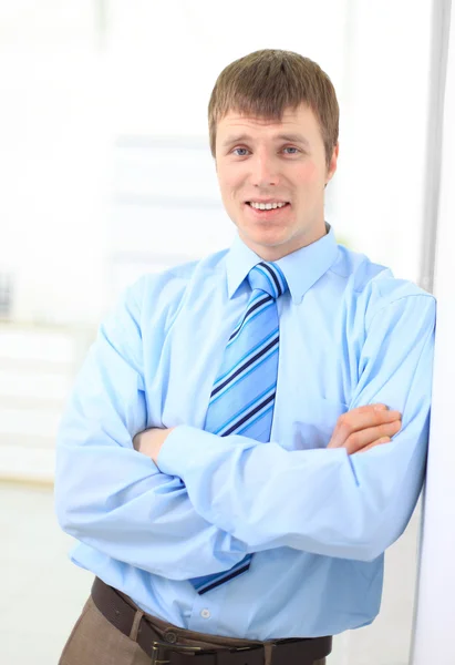 Porträtt av en lycklig ung affärsman lutande på väggen och titta på c — Stockfoto