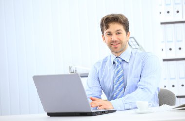 Closeup of employee in the office working on laptop computer clipart