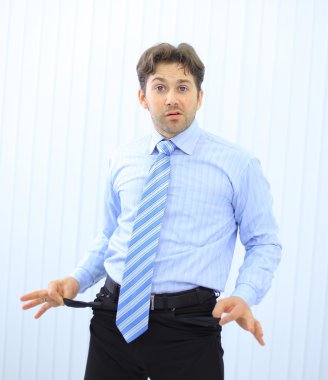 Young businessman showing empty pockets, no cas clipart