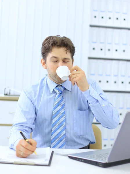 Porträt eines jungen Geschäftsführers, der Kaffee trinkt, während er die — Stockfoto