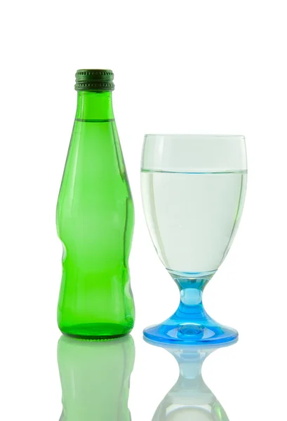 Μπουκάλι και το ποτήρι του μεταλλικού νερού αντικατοπτρίζεται στο w — Φωτογραφία Αρχείου