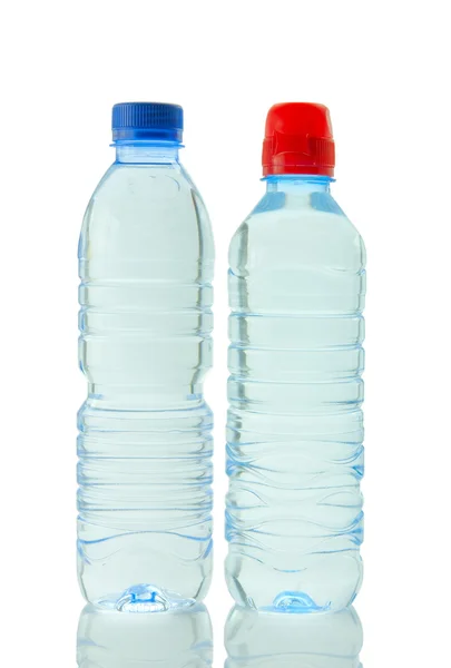 Garrafas de água mineral refletidas no bac branco — Fotografia de Stock