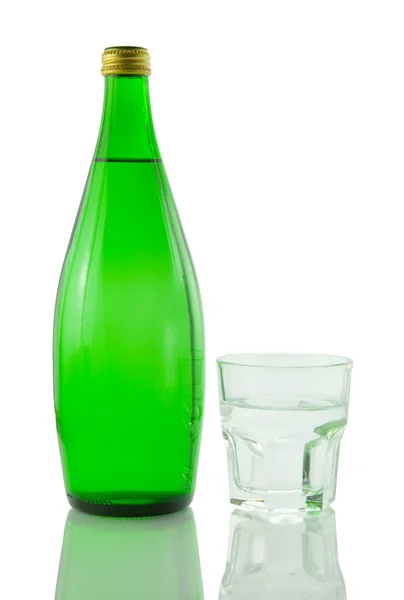Garrafa e vidro de água mineral refletida em w — Fotografia de Stock