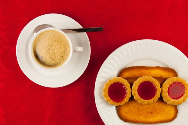 Café et biscuits sur fond rouge — Photo