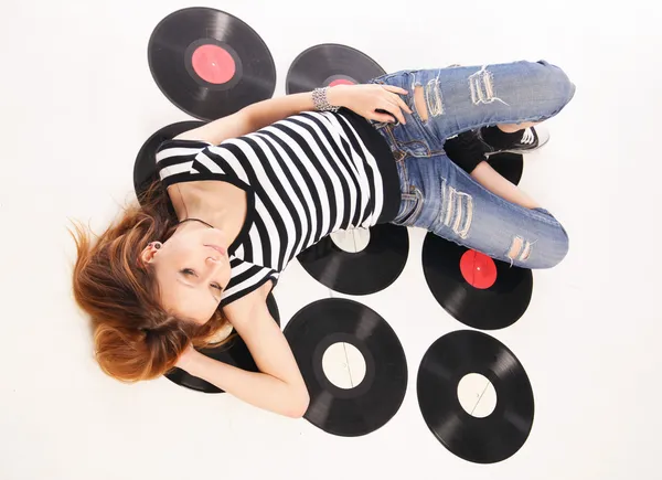 Girl lie on retro disks — Stock Photo, Image