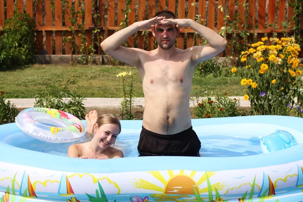 Młode pary kąpie się w basenie nadmuchiwane — Zdjęcie stockowe