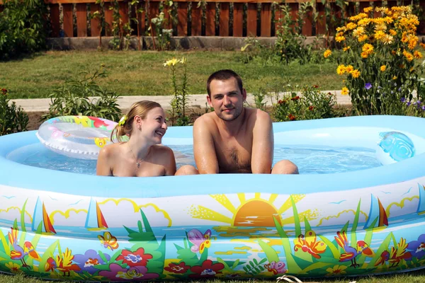 Молодые пары ванны в надувном бассейне — стоковое фото