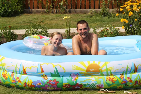 Pareja joven se baña en piscina inflable —  Fotos de Stock