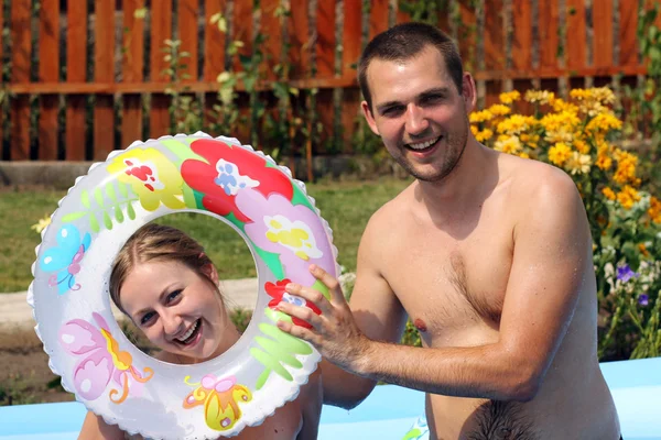 Giovane coppia si bagna in piscina gonfiabile — Foto Stock