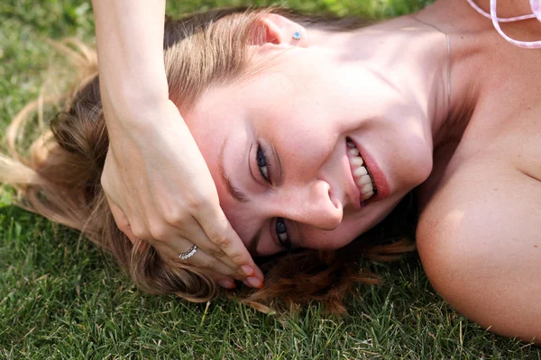 Женщина лежит на травяном поле в парке — стоковое фото