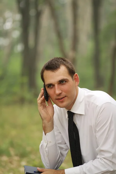 Telefon ederken çekici genç bir adam — Stok fotoğraf