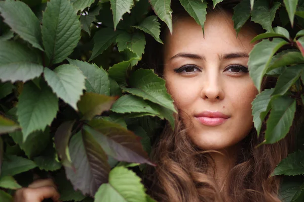 Portrét dívky v zelené listoví — Stock fotografie