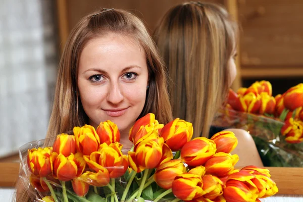 Blonde holding bunch of flowers — Stockfoto