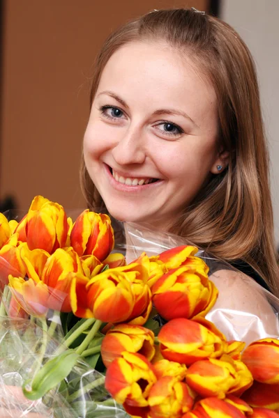 Blonde holding bunch of flowers — Stockfoto