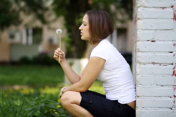 Womanl blows on a dandelion — Stock Photo, Image