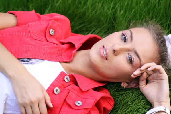 Carino giovane femmina sdraiata sul campo di erba al parco — Foto Stock