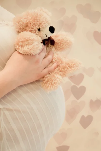 Těhotenství žena držící medvídek — Stock fotografie