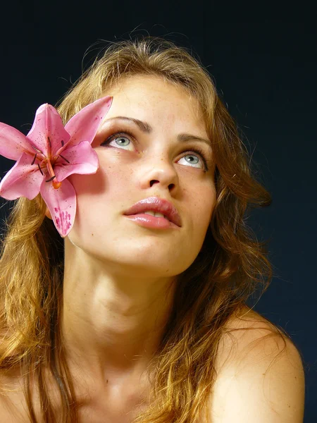 Girl with a lily in hairs — Stock Photo, Image