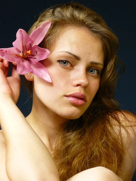 Young girl with a lily in hairs — Stock Photo, Image