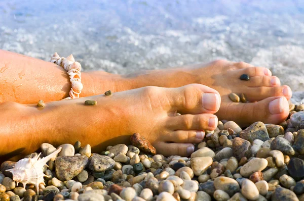 Pied de femme avec le bracelet coquille de mer — Photo