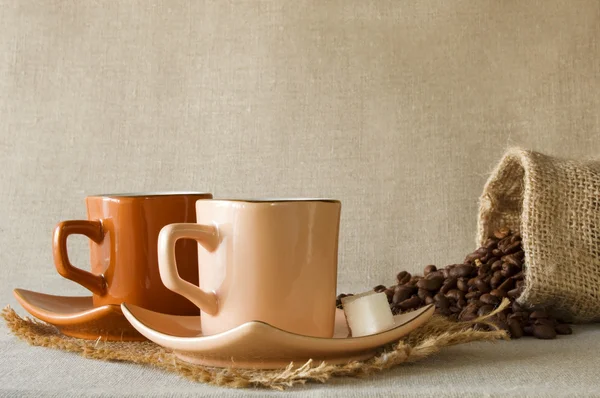 Kávová zrna a dvě čepice kávy — Stock fotografie