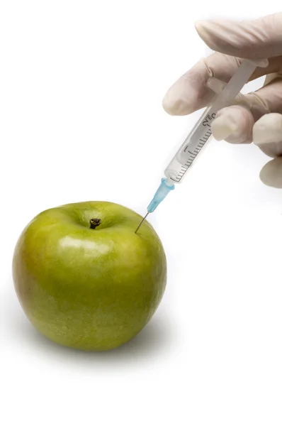 Manzana recibiendo una inyección con una jeringa . — Foto de Stock