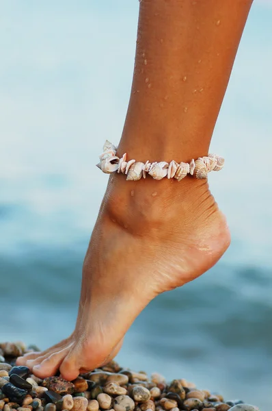 Πόδια της γυναίκας με τη θάλασσα κέλυφος βραχιόλι — Φωτογραφία Αρχείου
