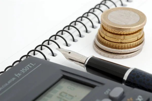 Érmék, toll és számológép — Stock Fotó