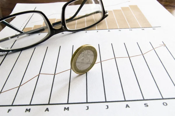 Stock chart with coinand glasses — Stock Photo, Image