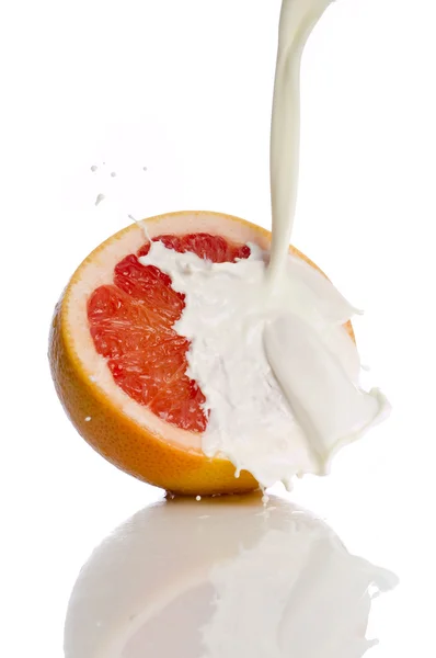 Grapefruit with splashing milk — Stock Photo, Image
