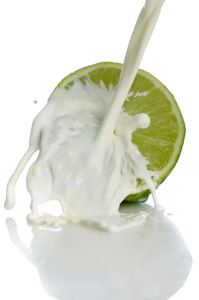 Lime with splashing milk — Stock Photo, Image