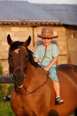 Child on brown horse clipart